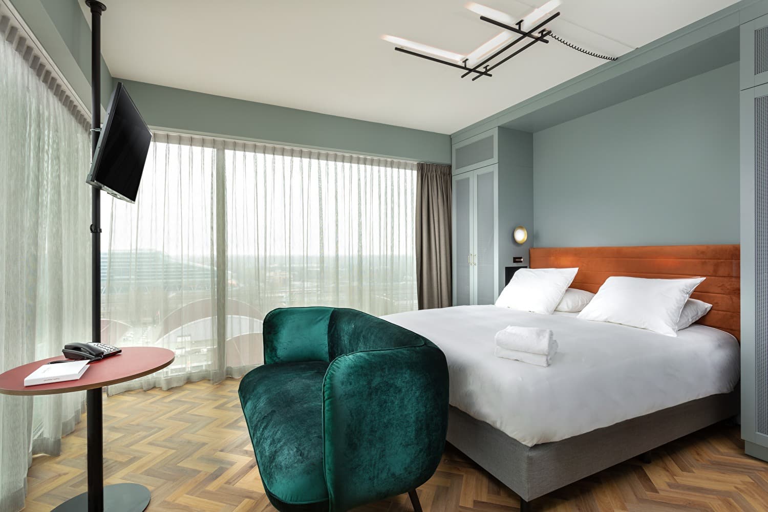 Gold Recovery Room with a double bed, green chair, and panoramic window
