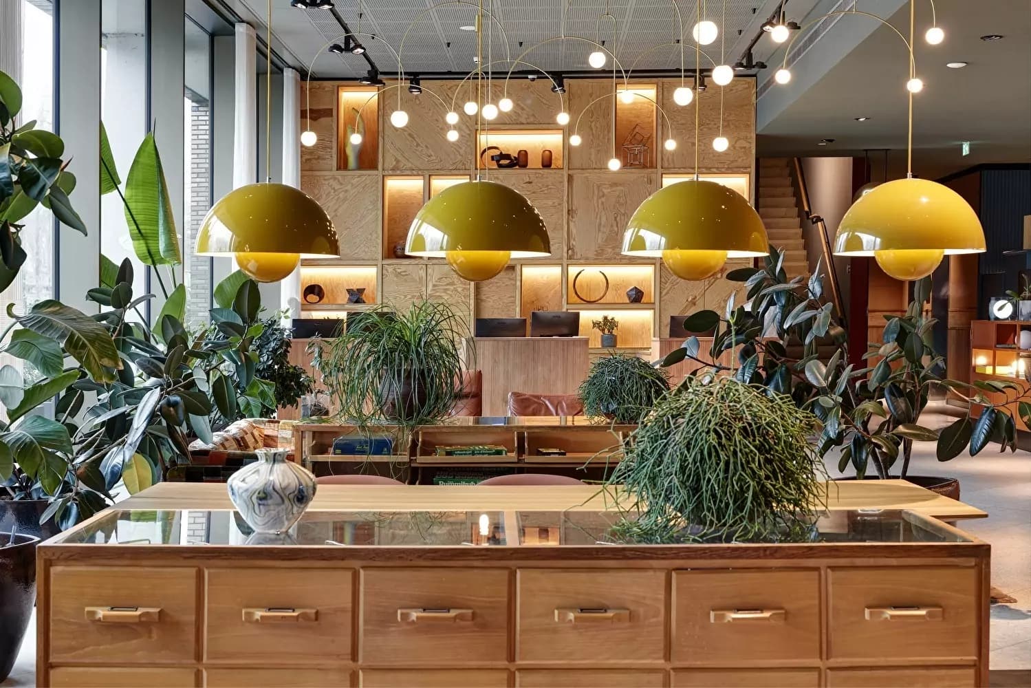 Plant-filled lobby and reception at Olympic Hotel Amsterdam